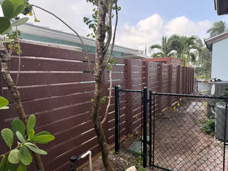 Brown wood privacy fence after PPW staining and exterior finishing work
