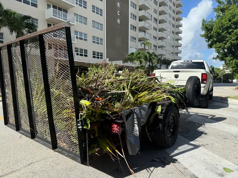 PPW landscaping cleanup trailer loaded with green debris after service